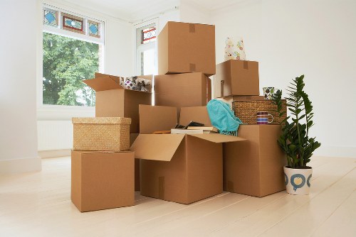 Removal team carrying furniture through a London property staircase